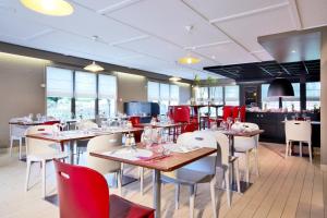 维耶尔宗钟楼维耶宗酒店的配有木桌和椅子以及红色椅子的餐厅