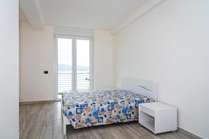 费拉约港Appartamento Fronte Mare的白色的卧室设有床和窗户