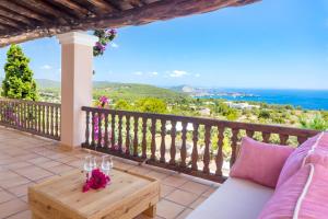 圣何塞德萨塔莱阿Villa Cas Berris的阳台配有沙发和带酒杯的桌子。