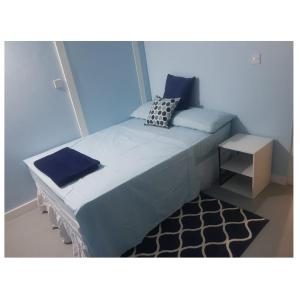 Cap EstateCareffe Suites Unit 4的一间蓝色的卧室,配有一张床和一张小桌子