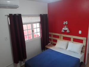 马塞约Pousada e Hostel Boneca de Pano的一间卧室配有一张红色墙壁的床