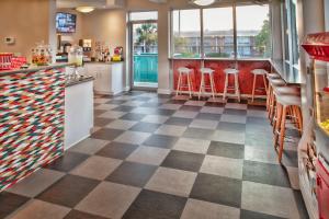 萨凡纳雷鸟酒店的餐厅设有格子地板和红色凳子