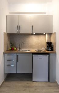 尼基季Varka Rooms的厨房配有白色橱柜和水槽
