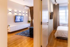 诺维萨德Dali Apartments Pupin Palace的一间带一张床的小卧室和一间带窗户的房间
