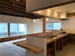 Saikiゲストハウス さんかくワサビ的一个带大型木制台面的大厨房