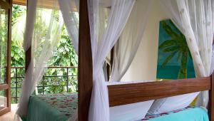坎布里Estalagem Camburi的一间卧室配有带窗帘的床和窗户