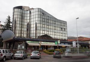 普拉托费鲁奇住宅酒店的一座大型玻璃建筑,停车场内有车辆停放
