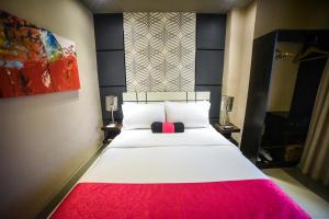 麦克坦Eloisa Royal Suites的卧室配有一张大白色床和红色毯子