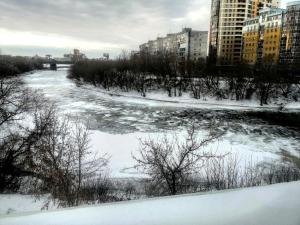 鄂木斯克Отель-хостел ПушкинЪ的积雪和建筑物的城市河流