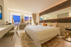 万里区薆悦酒店野柳渡假馆的卧室配有一张白色大床、一张书桌和一张书桌