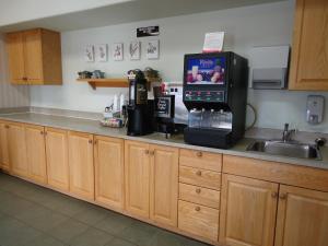 Swan River天鹅谷速8汽车旅馆的厨房柜台配有微波炉和水槽