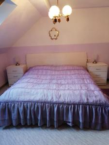 穆赫克雷斯的艾根Appartmenthaus Kern的一间卧室配有一张带2晚台的紫色床