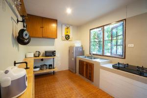 苏林海滩苏林度假屋的厨房配有水槽、冰箱和窗户。