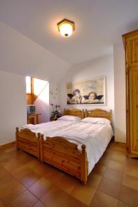 Comeglians阿尔伯格艾利阿尔皮酒店的一间卧室配有一张大木床。