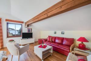 艾格斯塔特Alpenblick的客厅配有红色沙发和电视