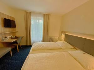 斯图加特罗曼庄园酒店的酒店客房配有两张床和一张书桌