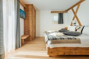科尔蒂纳丹佩佐Camina Suite and Spa的一间卧室配有一张带枕头的木床