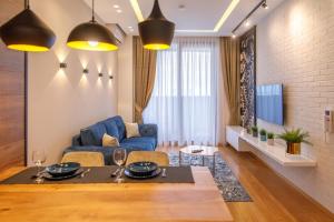 诺维萨德Dali Apartments Pupin Palace的客厅配有桌子和蓝色沙发