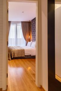 诺维萨德Dali Apartments Pupin Palace的一间卧室设有一张床和一个窗口
