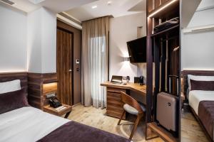 塞萨洛尼基Imperial Plus Urban Smart Hotel Thessaloniki的配有一张床和一张书桌的酒店客房