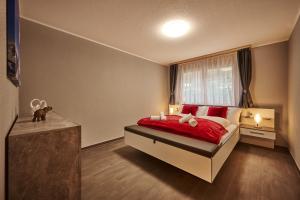 劳特布龙嫩Apartment Breithorn - Charming home - free parking & Wifi的一间卧室设有红色的床和窗户。