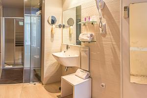 巴塞罗那圣家堂旅馆的一间带水槽和镜子的浴室
