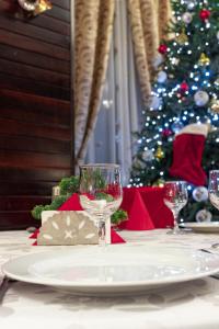 DorohoiPensiunea Splendid的桌子上放着酒杯,还有圣诞树