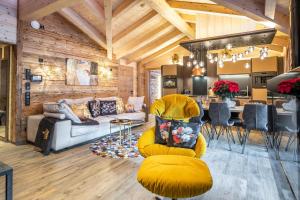 卡普伦The Kaprun Edition - Luxury Chalets & Style Suites的一间带黄色沙发的客厅和一间厨房