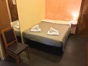 罗马天堂旅馆的一间小卧室,配有带毛巾的床