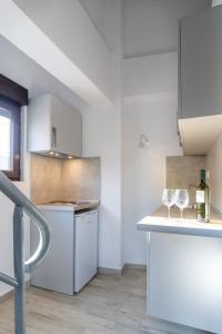 尼基季Varka Rooms的白色的厨房,在柜台上放有两杯酒杯