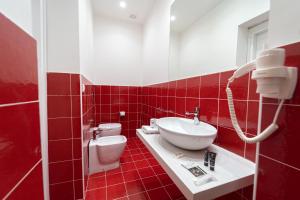那不勒斯HG Boutique Toledo, Napoli Centro, by ClaPa Group的红色瓷砖浴室设有水槽和卫生间