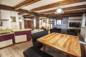卡纳泽伊Chalet Tobià的厨房以及带木桌和椅子的客厅。