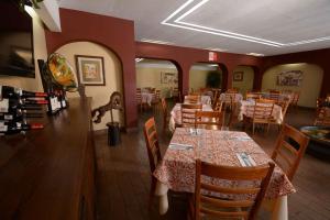 瓦哈卡市Hotel Hacienda的餐厅内带桌椅的用餐室