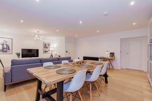 伍德斯托克Oxfordshire Living - The Churchill Apartment - Woodstock的客厅配有桌子和蓝色沙发