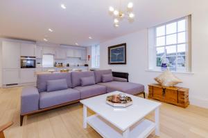 伍德斯托克Oxfordshire Living - The Churchill Apartment - Woodstock的客厅配有紫色沙发和桌子