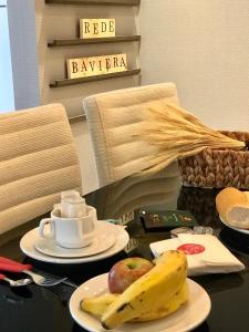 卡内拉Apartamento Vêneto的一张桌子,上面放着一盘水果和香蕉
