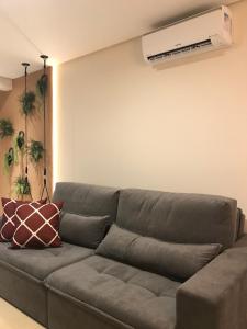 卡内拉Apartamento Vêneto的客厅配有沙发,墙上配有空调
