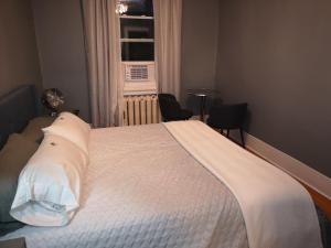蒙特利尔Room with King Bed in Shared 3 Bedroom Downtown的一间卧室配有一张带白色床单的床和一扇窗户。