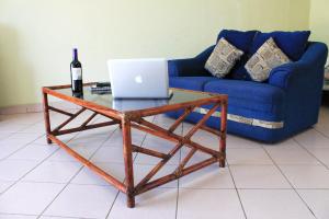 伊斯塔帕Coral Vista Del Mar的咖啡桌、一瓶葡萄酒和一台笔记本电脑