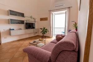 拉维罗Casa Vacanza da Giggino的客厅配有紫色沙发和电视