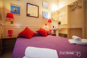 马德里拉丰塔纳旅馆的一间卧室配有一张带红色枕头和镜子的床