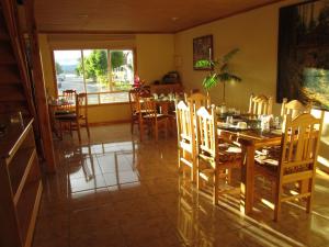 纳塔列斯港Patagonia Swiss House的一间带木桌和椅子的用餐室