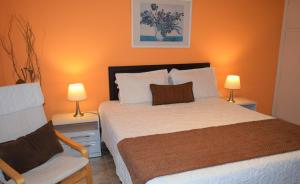 皮里亚波利斯旧金山梯田公寓式酒店的一间卧室配有一张床、一把椅子和两盏灯。
