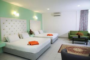 吉隆坡Akar Hotel Kampung Baru的酒店客房,设有两张床和一张沙发