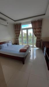波来古市Nhà nghỉ Bình Yên的一间卧室设有一张床和一个大窗户