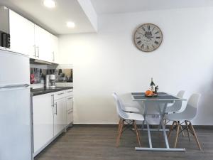 托雷维耶哈Beachfront modern and spacious apartment的厨房配有桌子和墙上的时钟