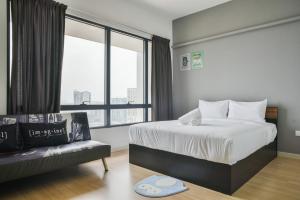 梳邦再也USJ One Premium Suites @Subang @Sunway @USJ的一间卧室配有一张床、一张沙发和一个窗口