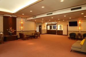 白马村橡树林酒店的大堂设有带椅子和平面电视的等候室