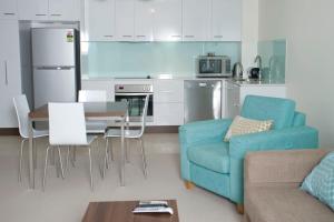 汤斯维尔伊塔拉公寓酒店的客厅配有蓝色的沙发和桌子