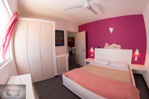 萨尔雷Cala da Lua apartments的一间小卧室,配有紫色的墙壁和一张床